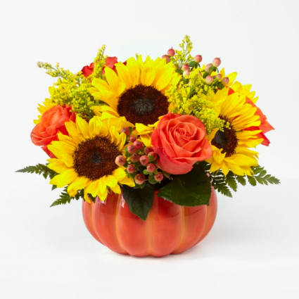 Sunflowers and coral roses arranged in a pumpkin-shaped vase