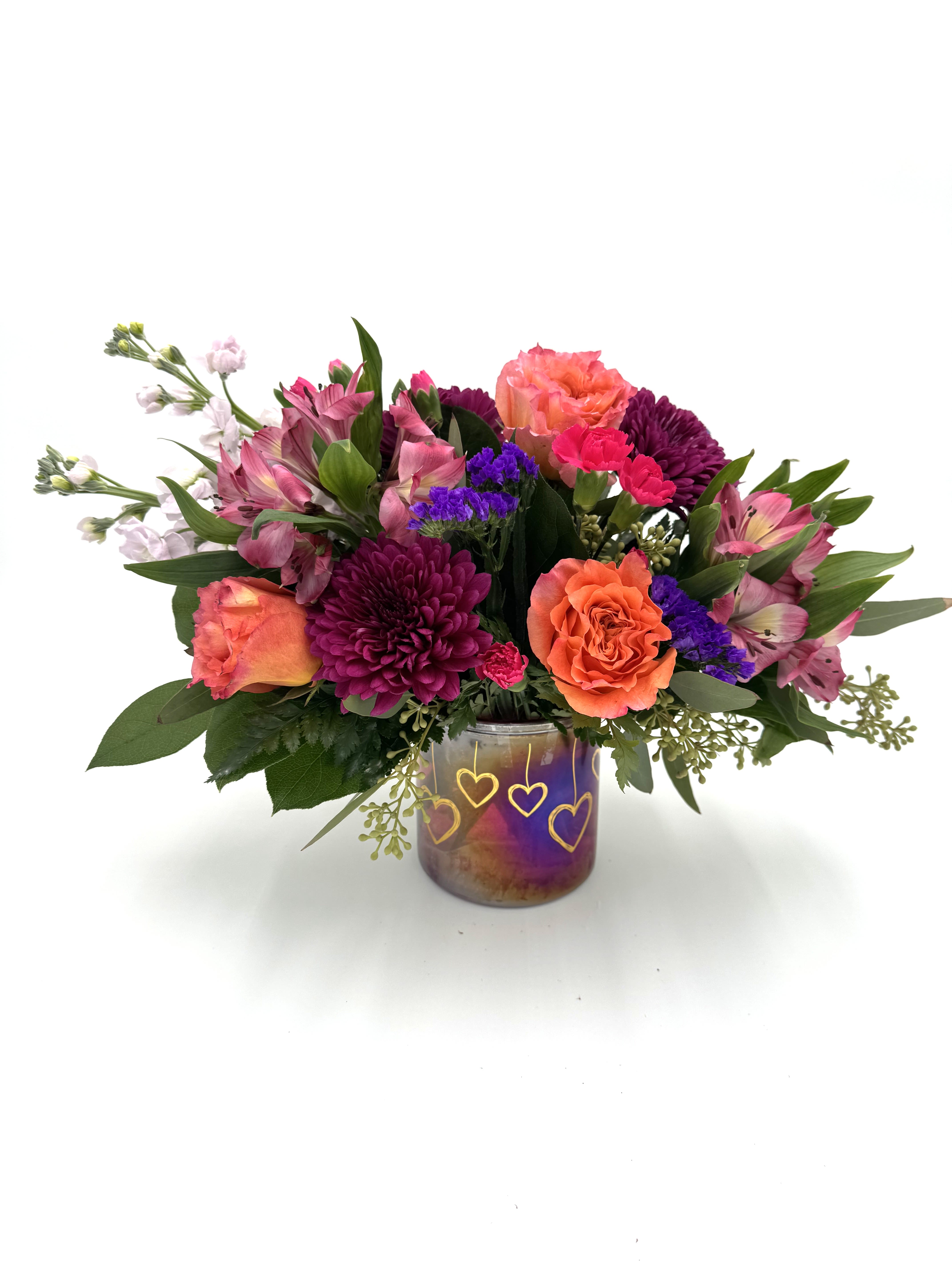 Mixed bouquet in a purple glass vase with heart designs