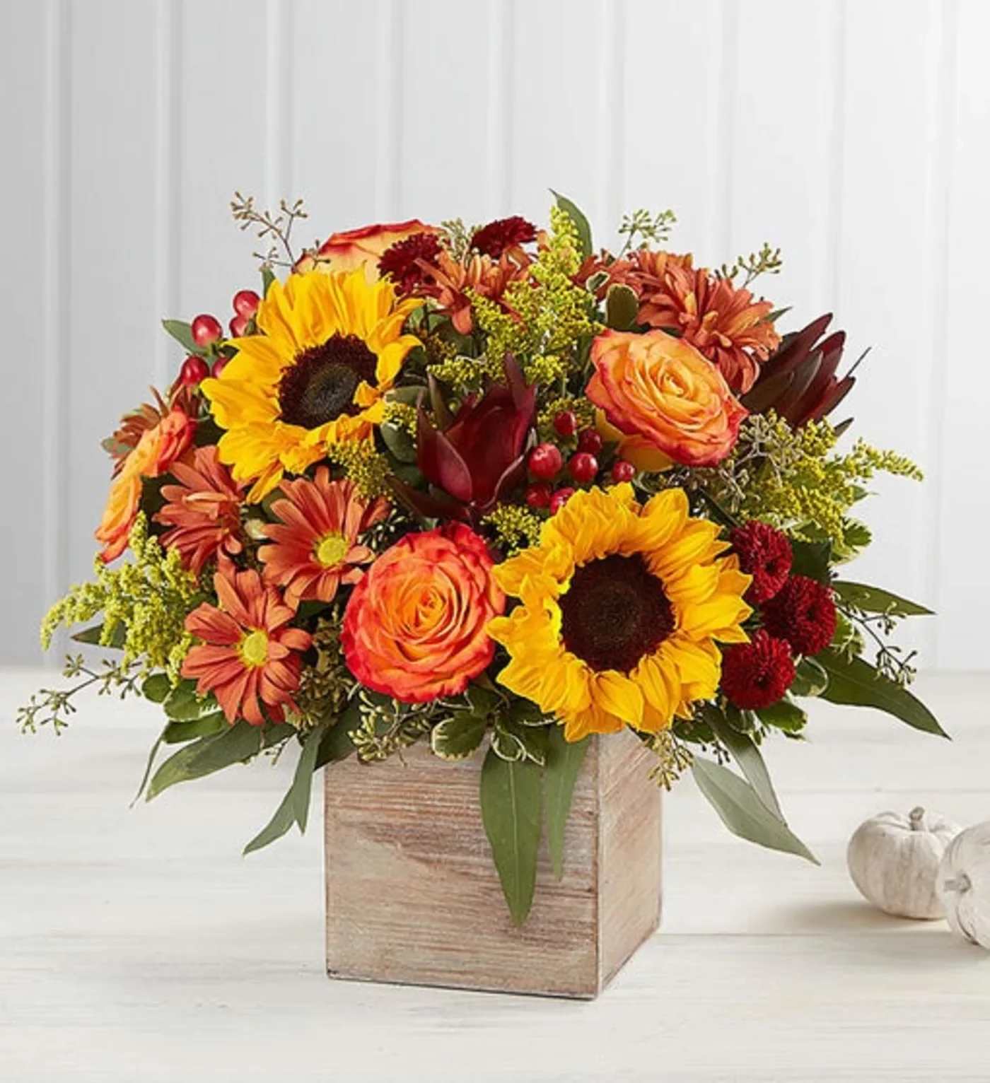 Autumn bouquet with sunflowers, orange roses, and mums in a wooden box