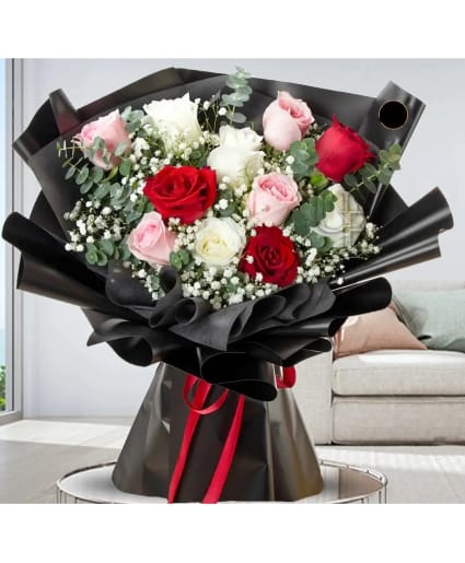 Bouquet of red, pink, and white roses wrapped in black paper