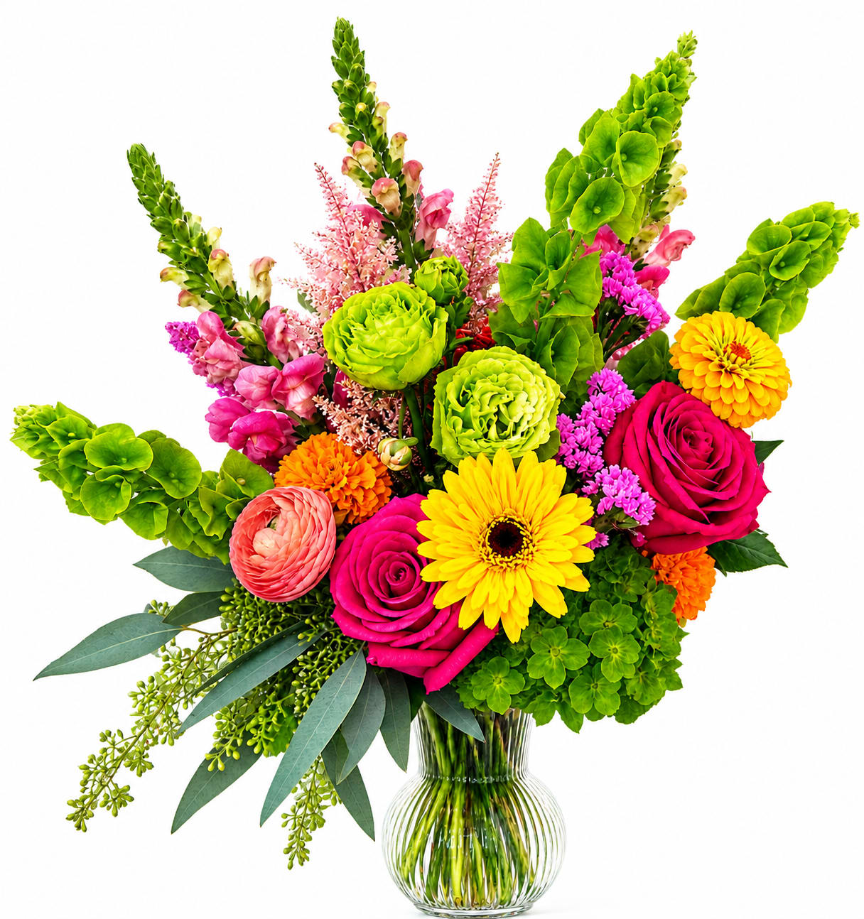 Bright mixed bouquet in a clear glass vase with roses, gerbera daisies, and green blooms