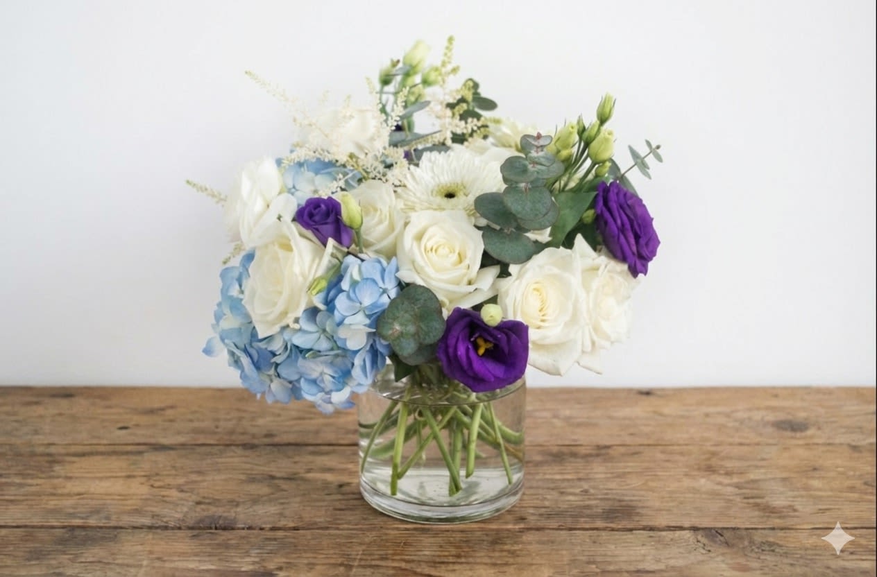 Soho - The arrangement is presented in a purple crystal vase. The flower comes in white, blue and purple color. 