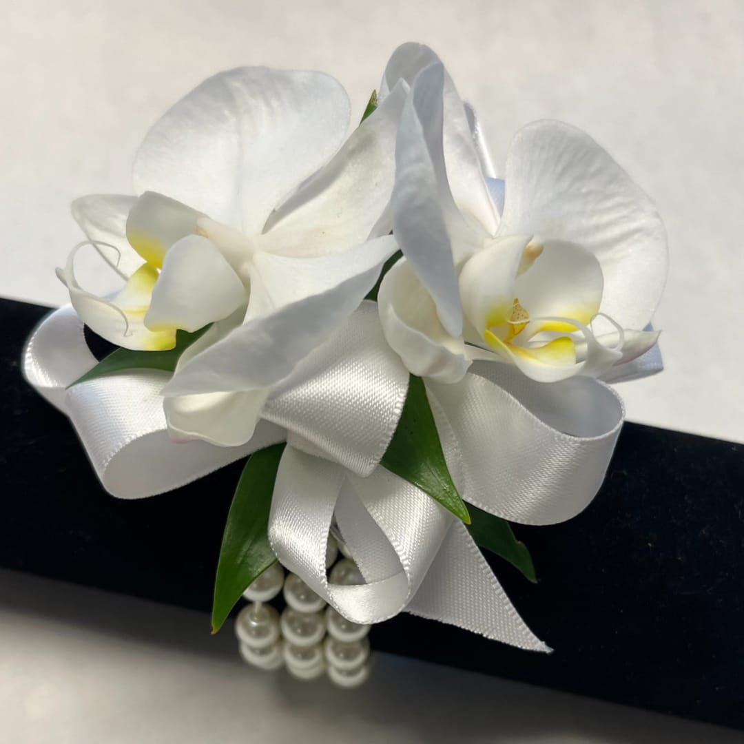 White orchid corsage with satin ribbon and pearl accents