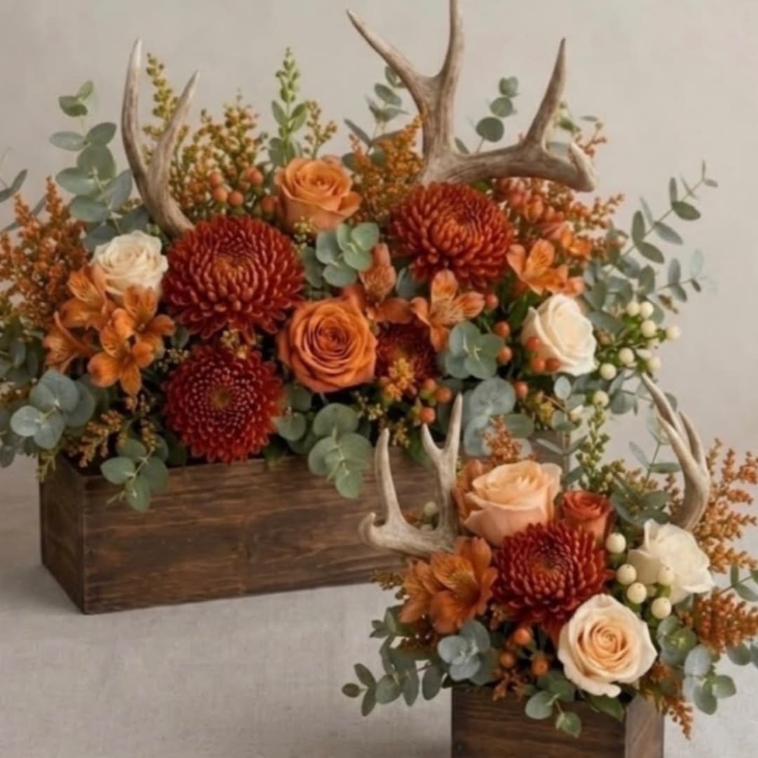 Orange and cream floral arrangements with antlers in wooden boxes