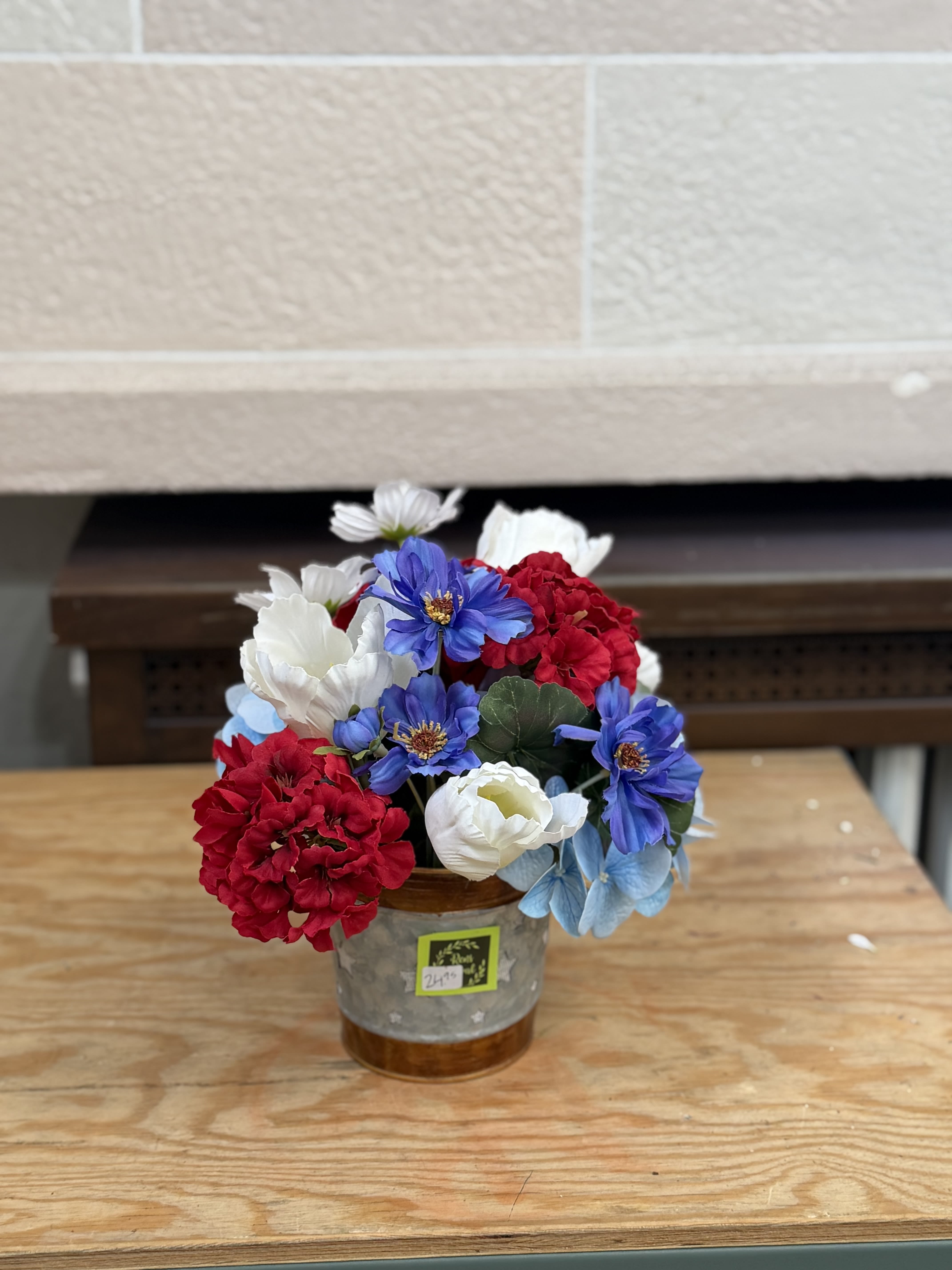 Artificial Red, White, and Blue Bouquet  - An artificial red white and blue bouquet in a bucket style container. 