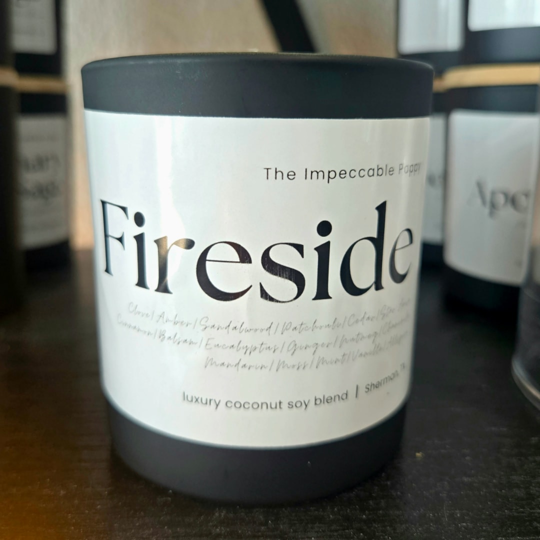 Black candle jar labeled "Fireside" on a shelf
