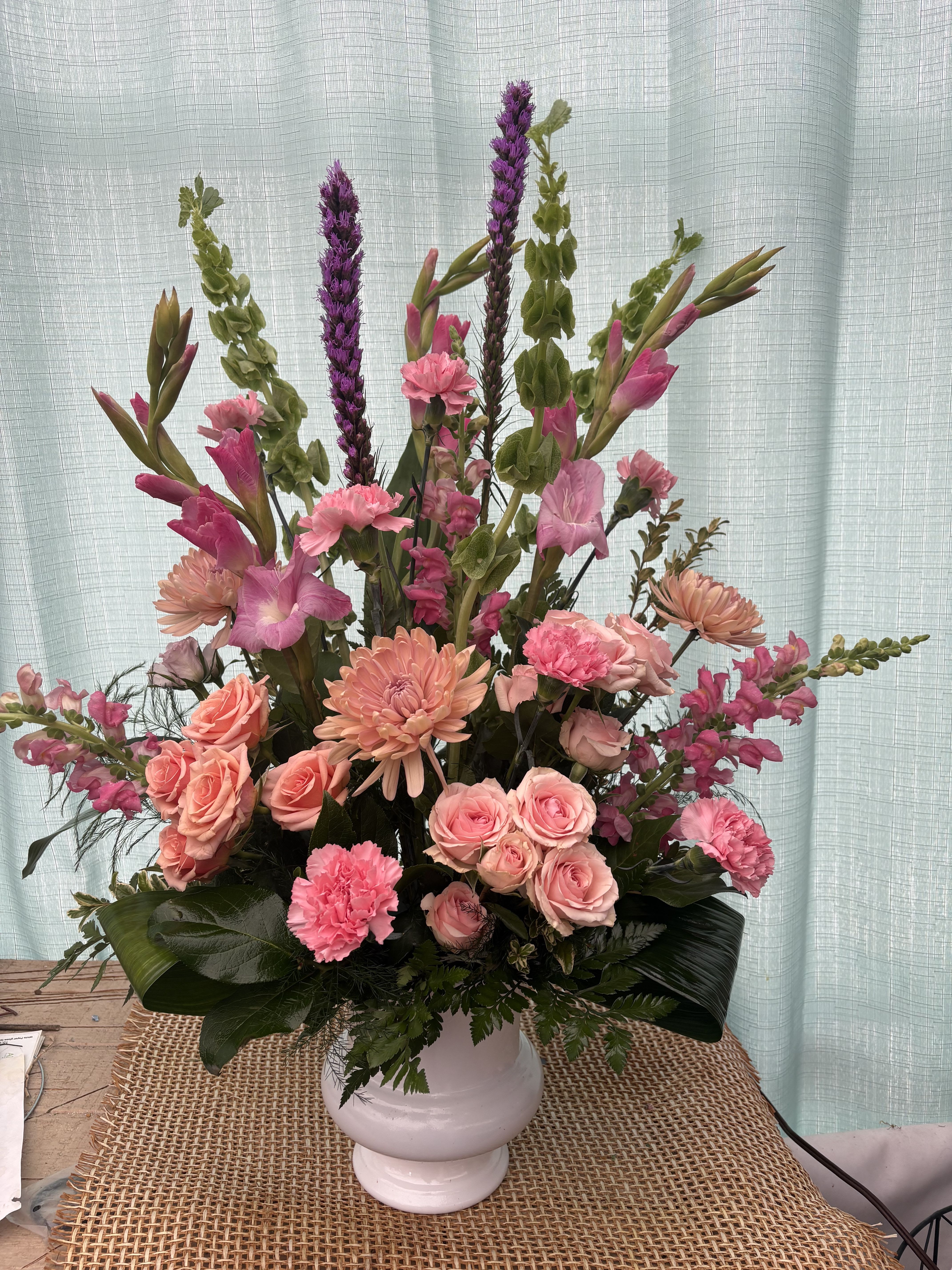Pink and peach floral arrangement in a white vase