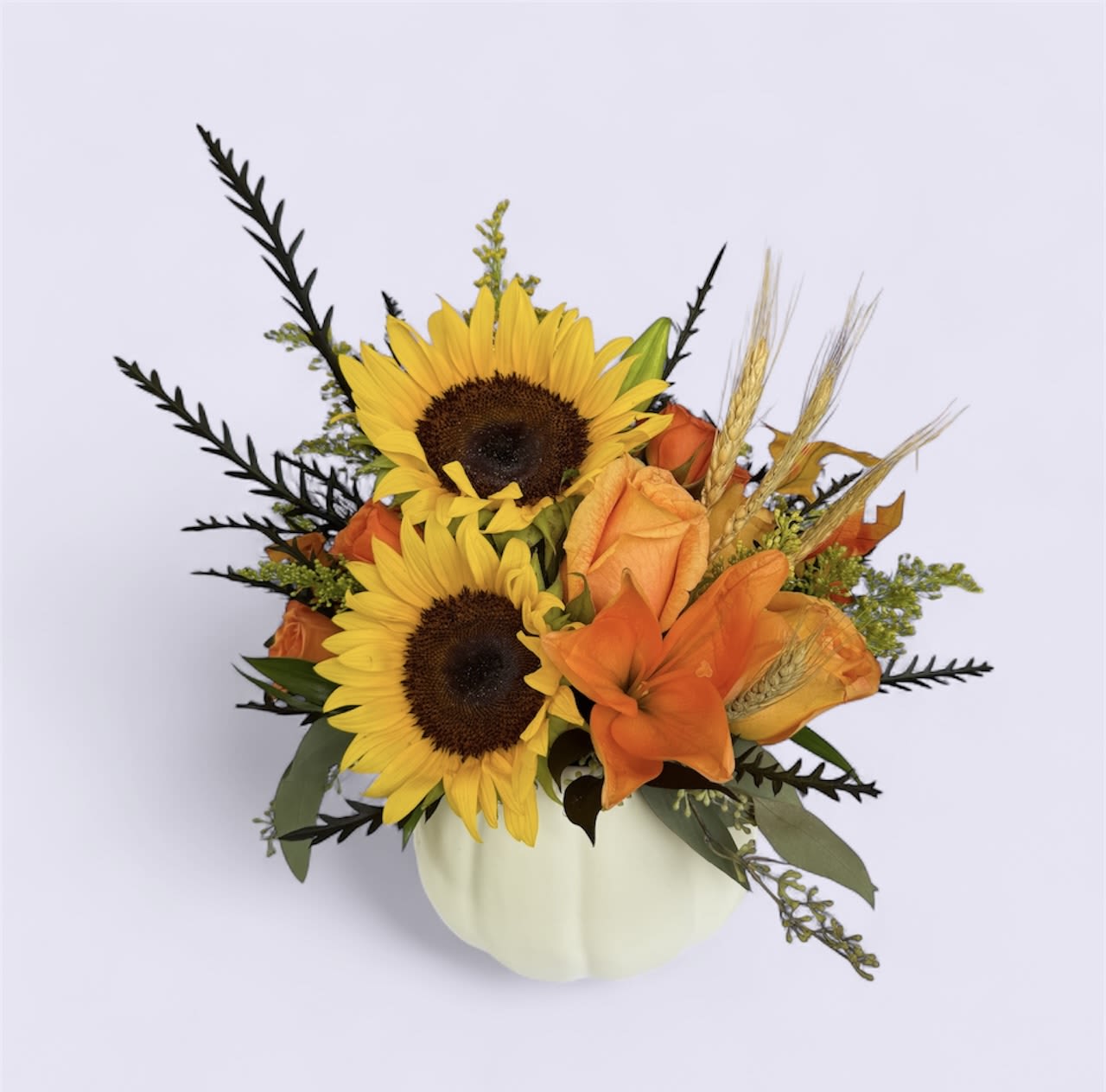 Sunflower and orange rose arrangement in a white pumpkin vase