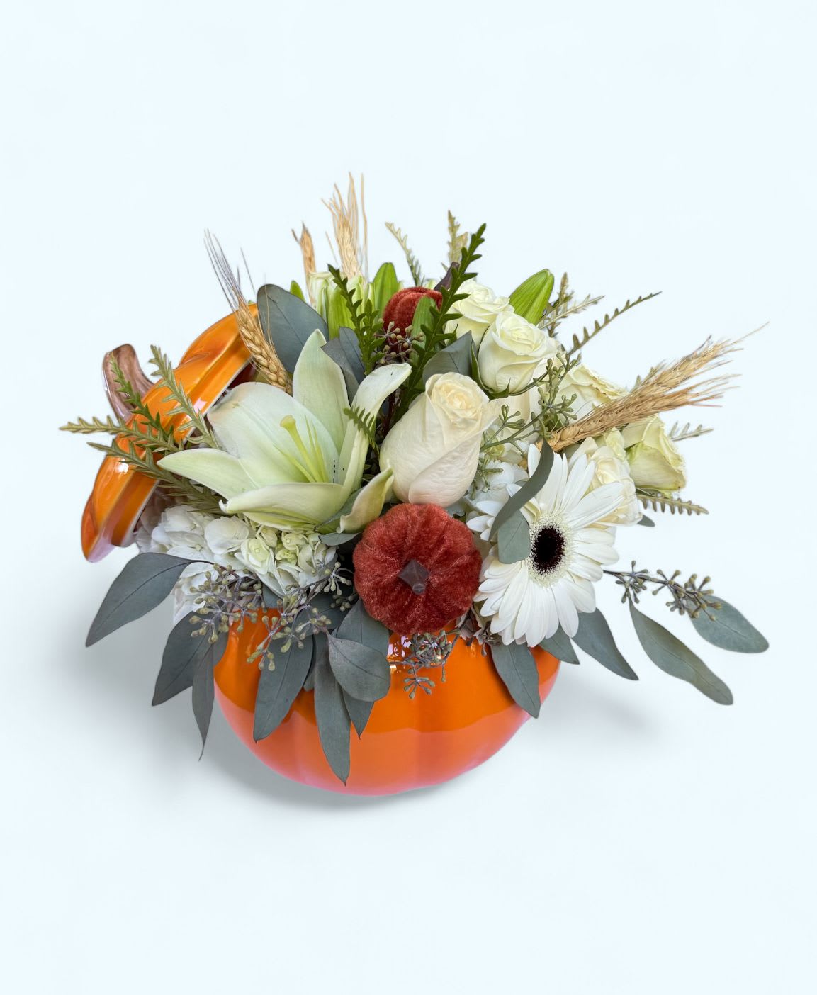 White floral arrangement in an orange pumpkin-shaped container
