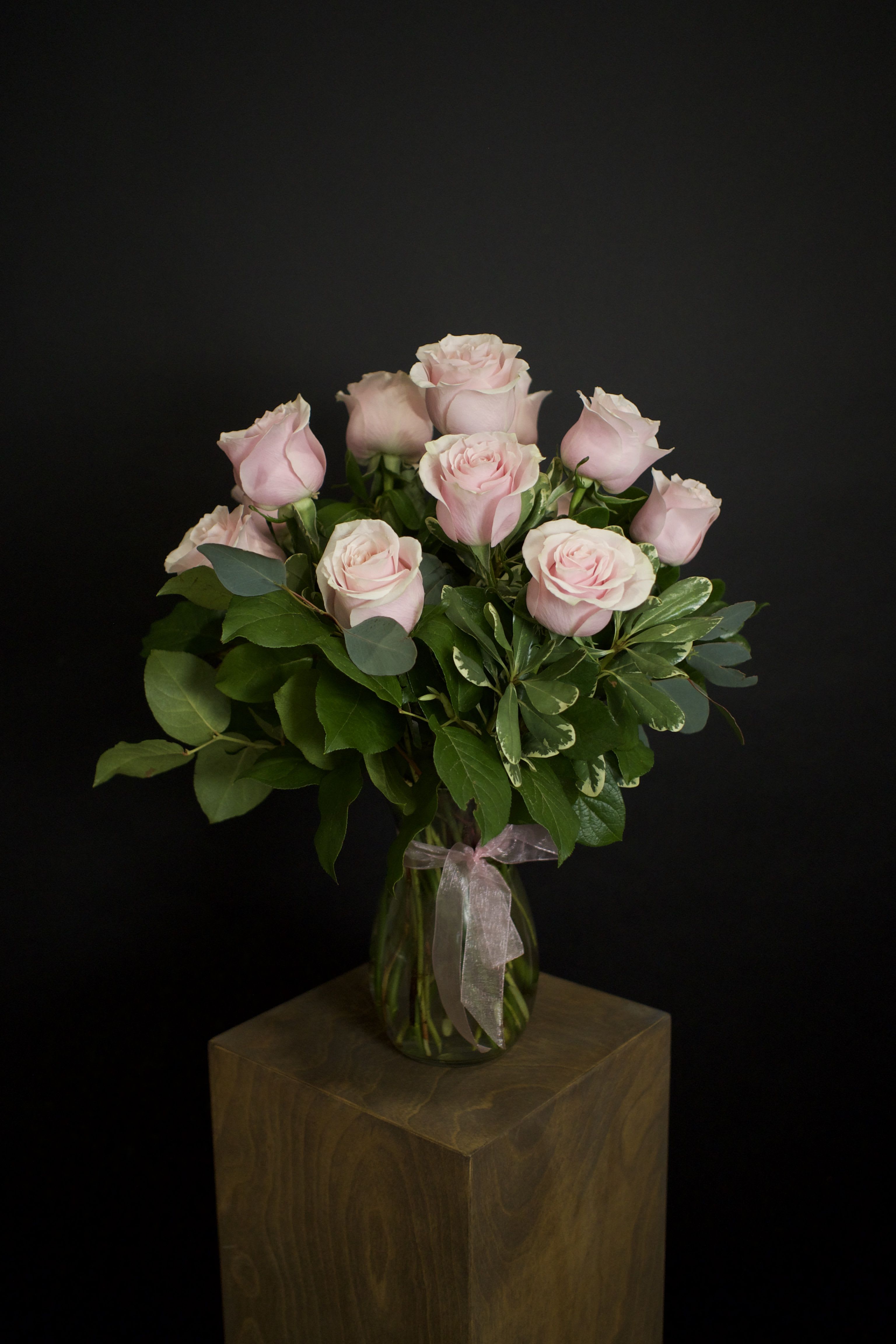 One Dozen Light Pink Roses - Vase Arrangement  - One dozen light pink roses in a vase    Timeless and elegant, this arrangement features 12 premium light pink roses in a clear glass vase, accented with lush greenery and a satin ribbon. Perfect for "anniversaries, Valentine’s Day, or any romantic occasion", it’s a classic way to show love and appreciation. 