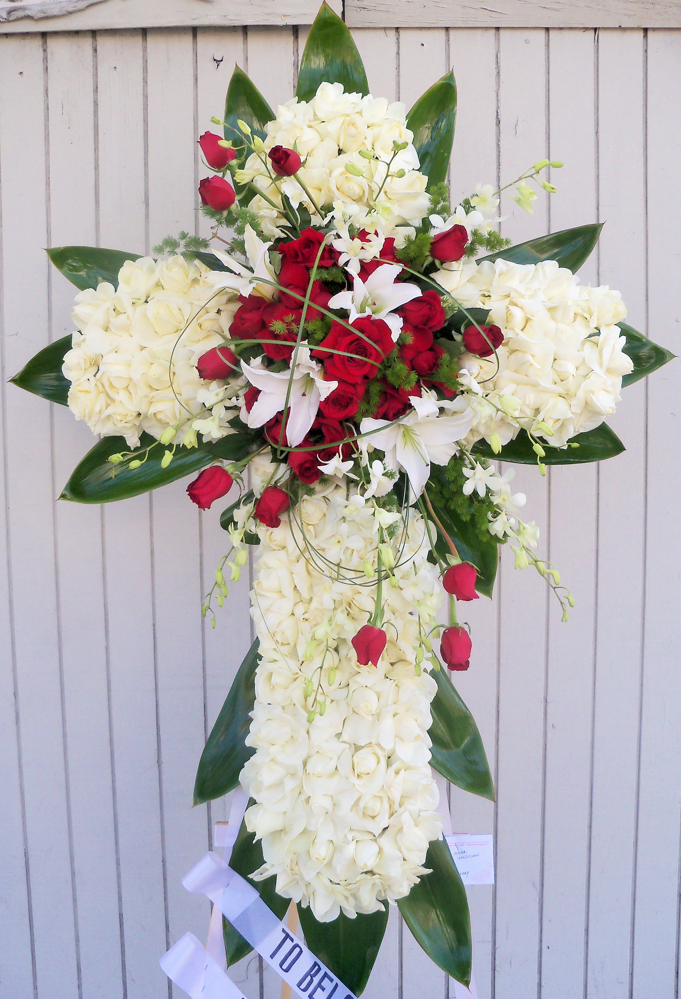 Standing floral cross with white and red roses and lilies