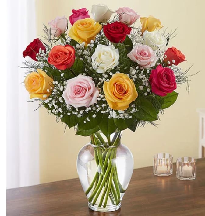 Mixed roses in a clear glass vase with baby's breath