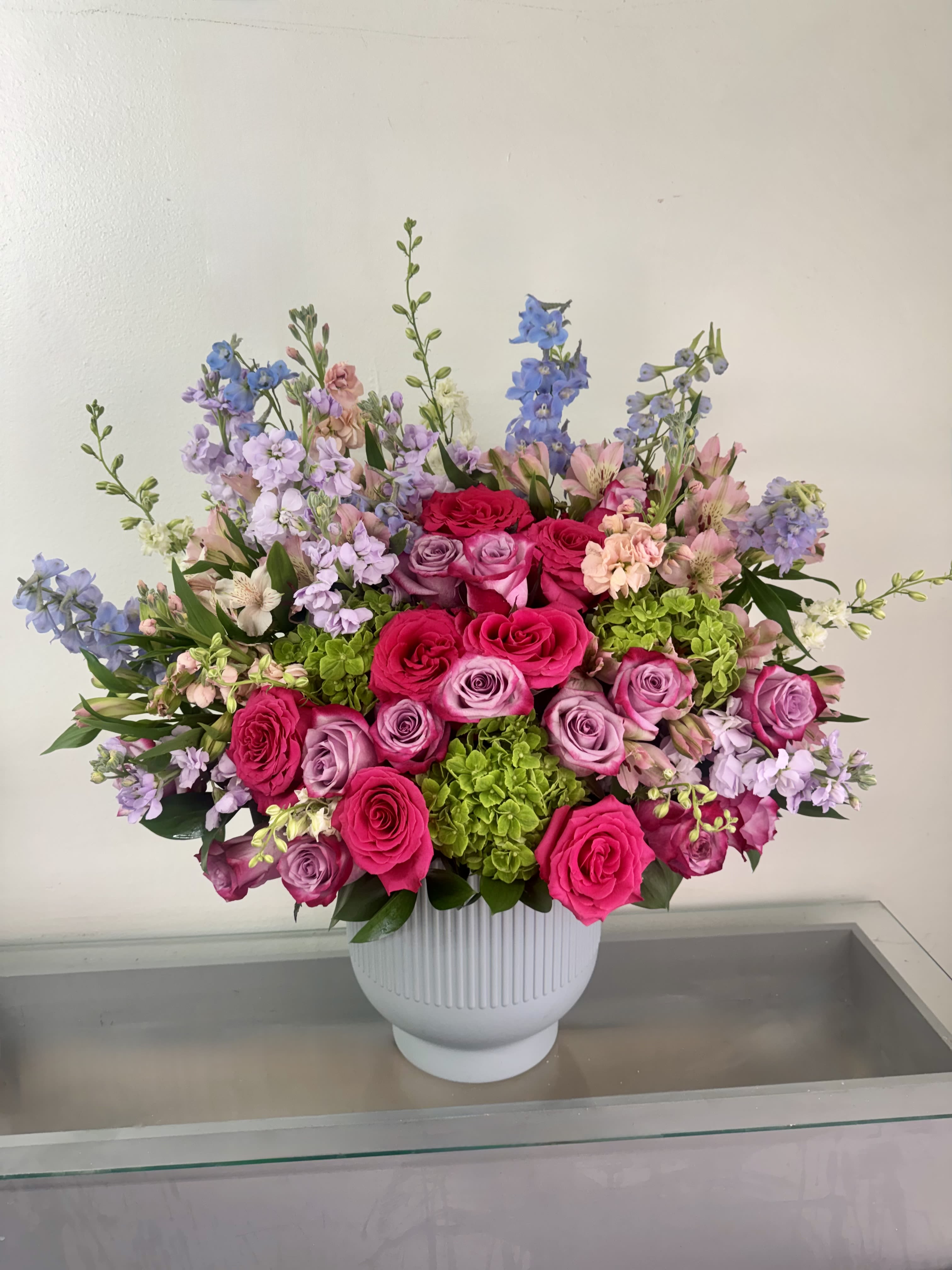 Blush &amp; Bloom - Blush &amp; Bloom is a lush, garden-inspired arrangement that brings together vibrant hot pink roses, soft lavender roses, fresh green hydrangea, fragrant stock, and premium seasonal blooms in a beautiful ceramic vase. Designed with rich texture, graceful movement, and a harmonious blend of colors, this elegant arrangement makes a beautiful gift for birthdays, anniversaries, congratulations, get well wishes, new babies, thank yous, or simply to brighten someone's day.