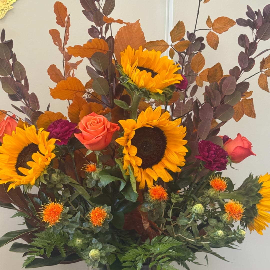 Bouquet with sunflowers, coral roses, and purple carnations