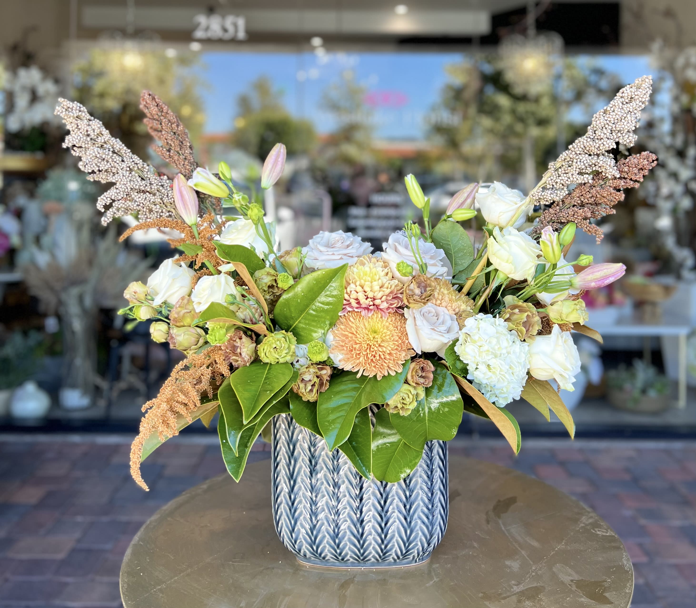 Mixed bouquet in a blue ceramic vase with white and peach blooms