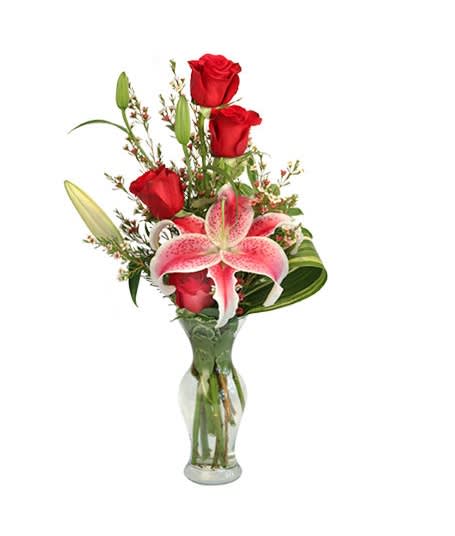 Red roses and pink lilies in a clear glass vase