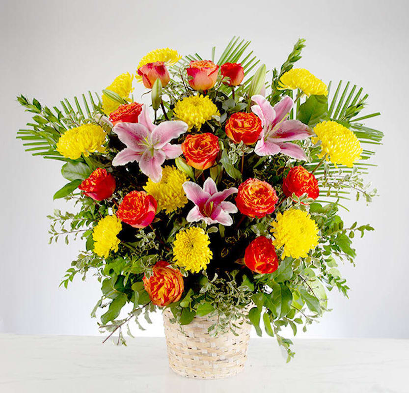 Spring Morning Bouquet - This colorful and bright basket full of roses, lilies and chrysanthemums symbolizes a life well lived to its fullest! Fitting for any type of service whether to send to home or a memorial.    Approximately 24" H x 16" W
