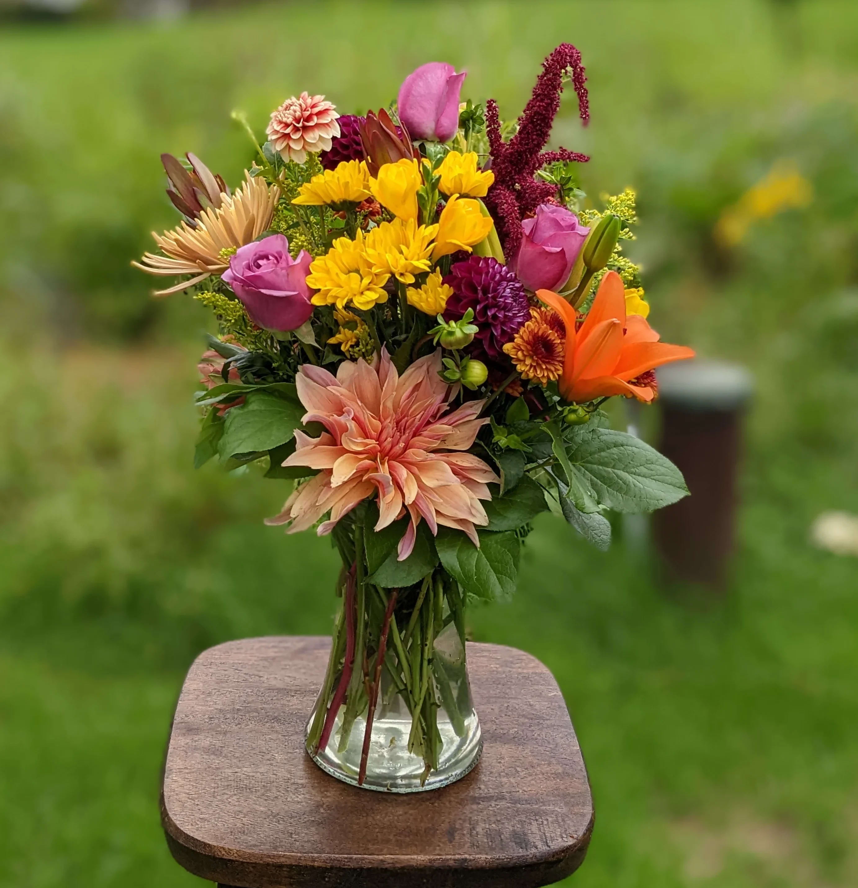 Mixed bouquet of bright flowers in a clear glass vase