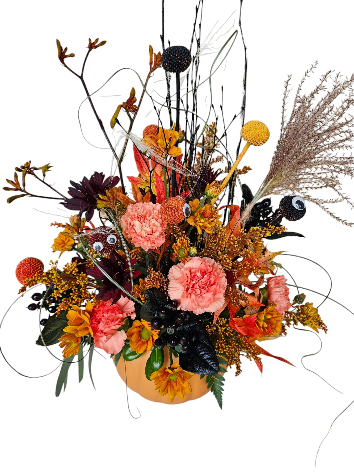 Autumn floral arrangement in a pumpkin-shaped container with pink and orange blooms