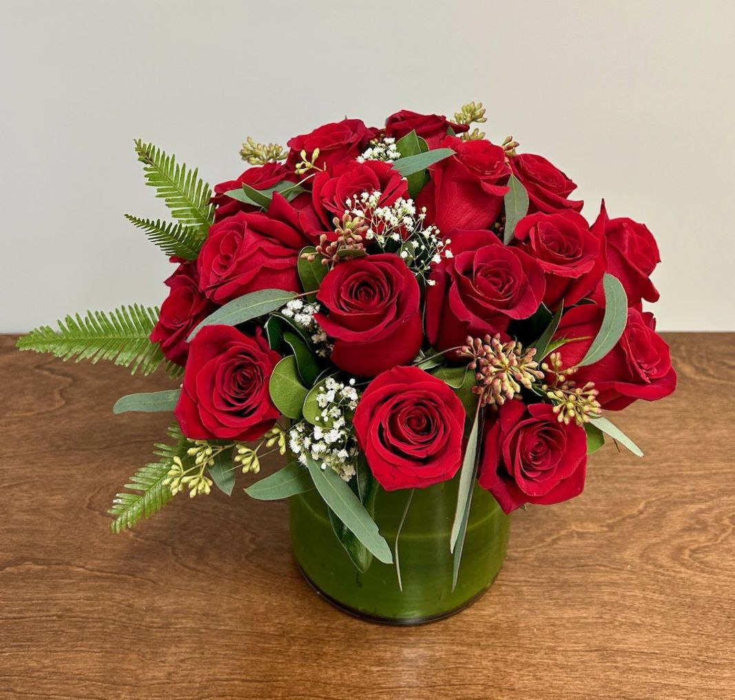 Red rose bouquet in a green glass vase
