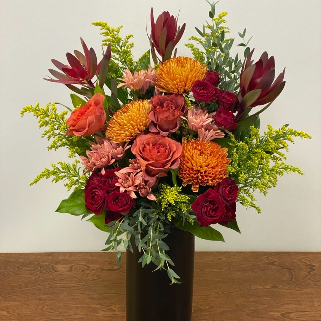 Mixed bouquet of roses and chrysanthemums in a black vase