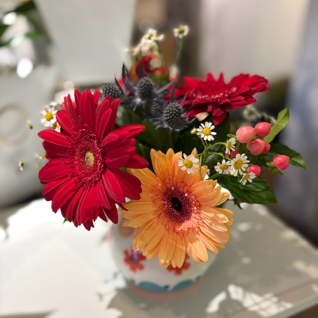 Colorful gerbera daisy bouquet in a patterned vase