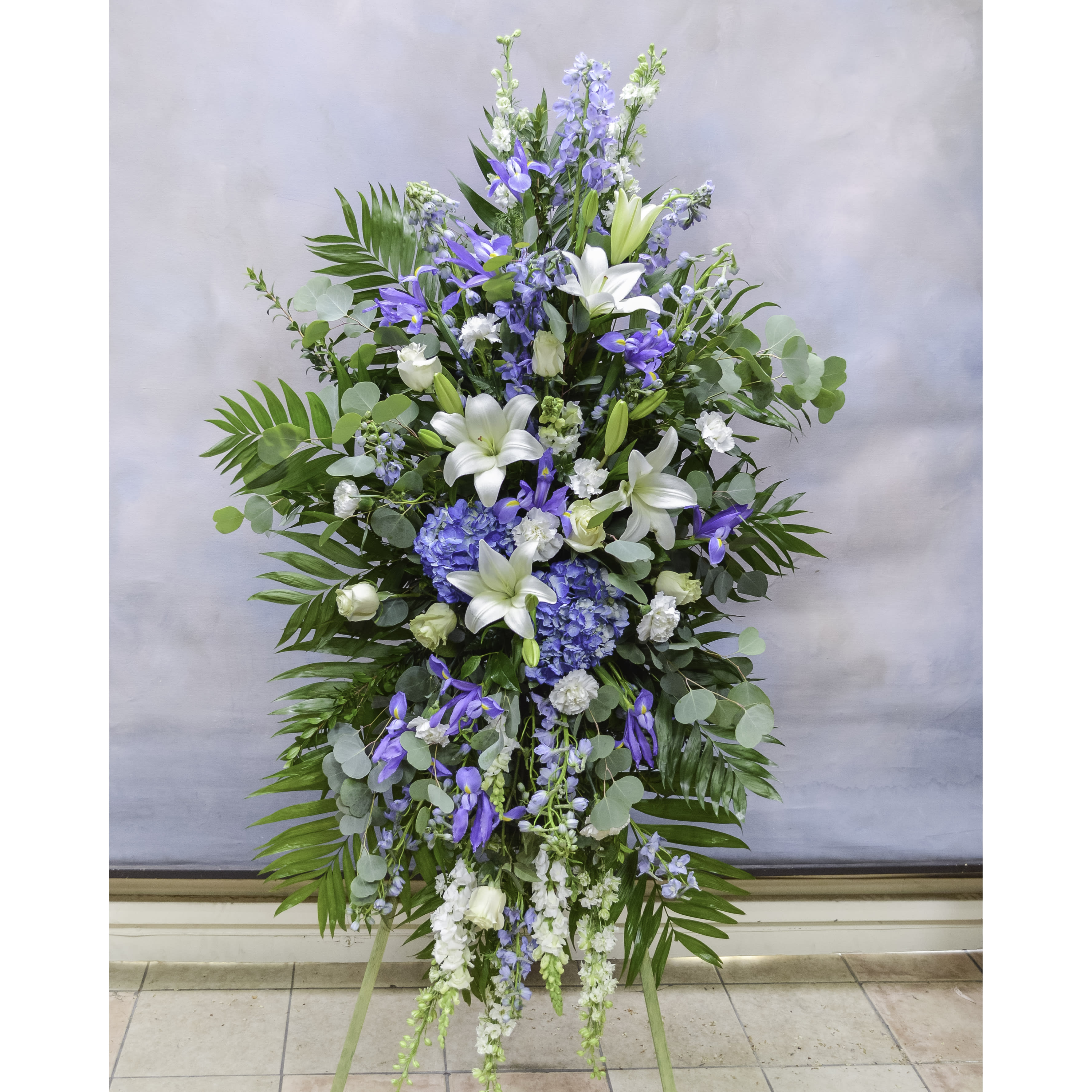Tall blue and white floral standing spray on an easel