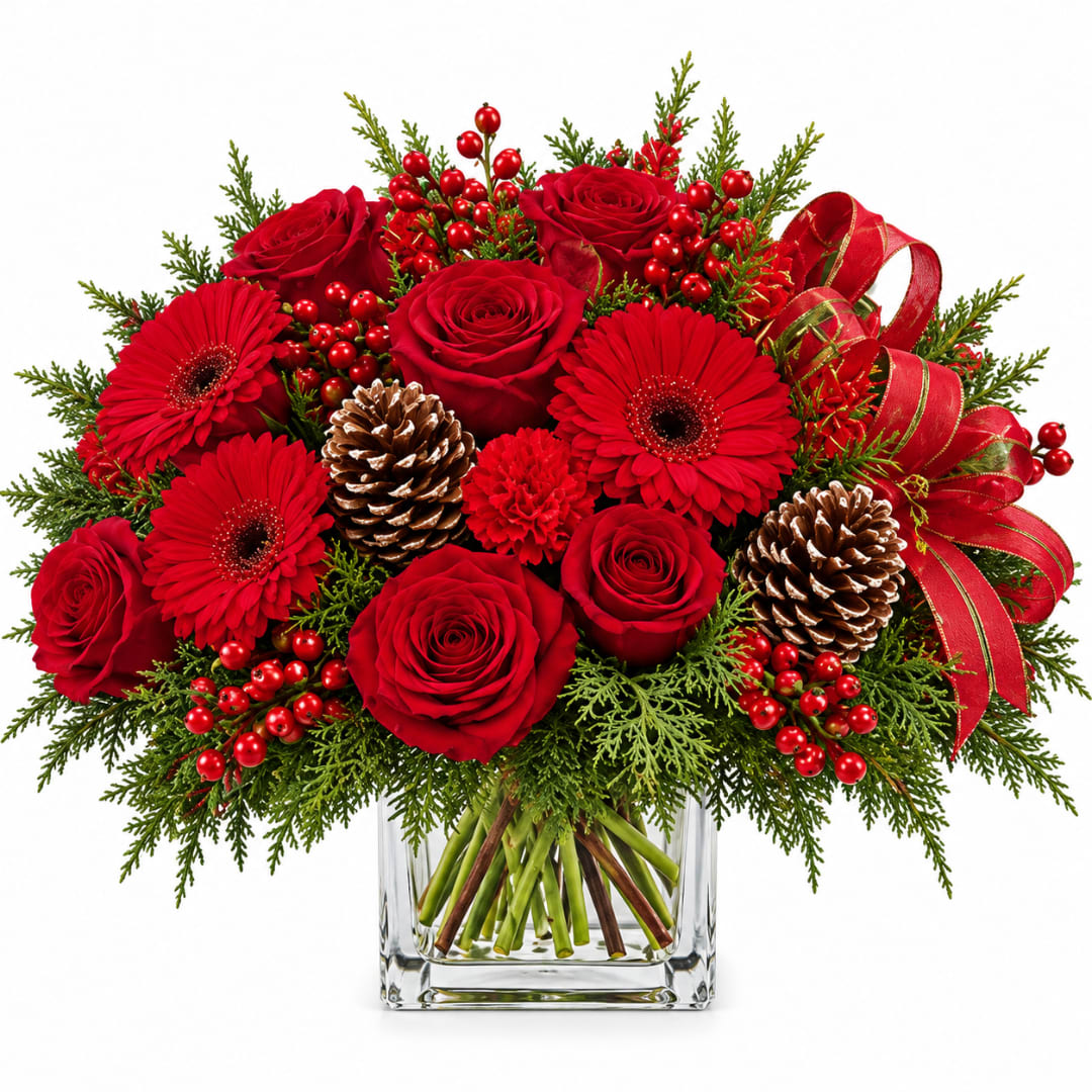 Red roses and gerbera daisies in a glass vase with pinecones and ribbon