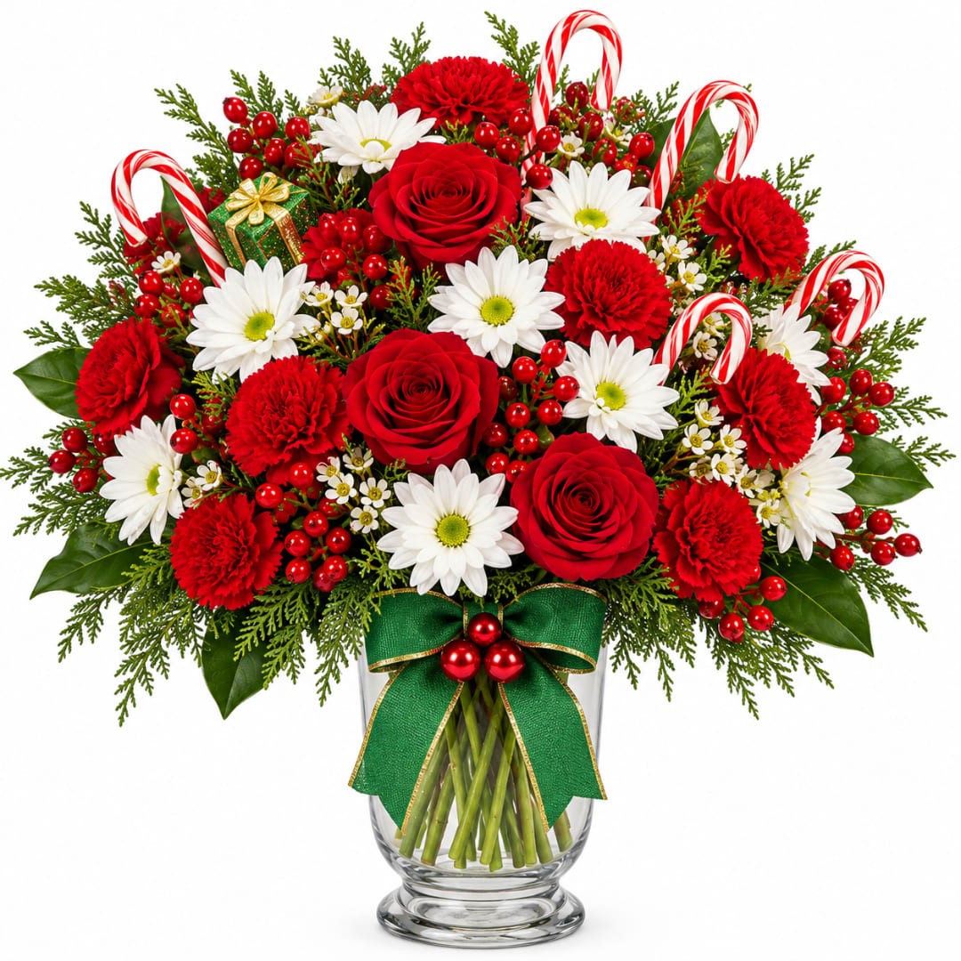 Candy Cane Vase - A festive mix of red roses, carnations, white daisies, and holiday greenery, accented with berries, candy canes, and a cheerful green bow. A fun and festive Christmas favorite.