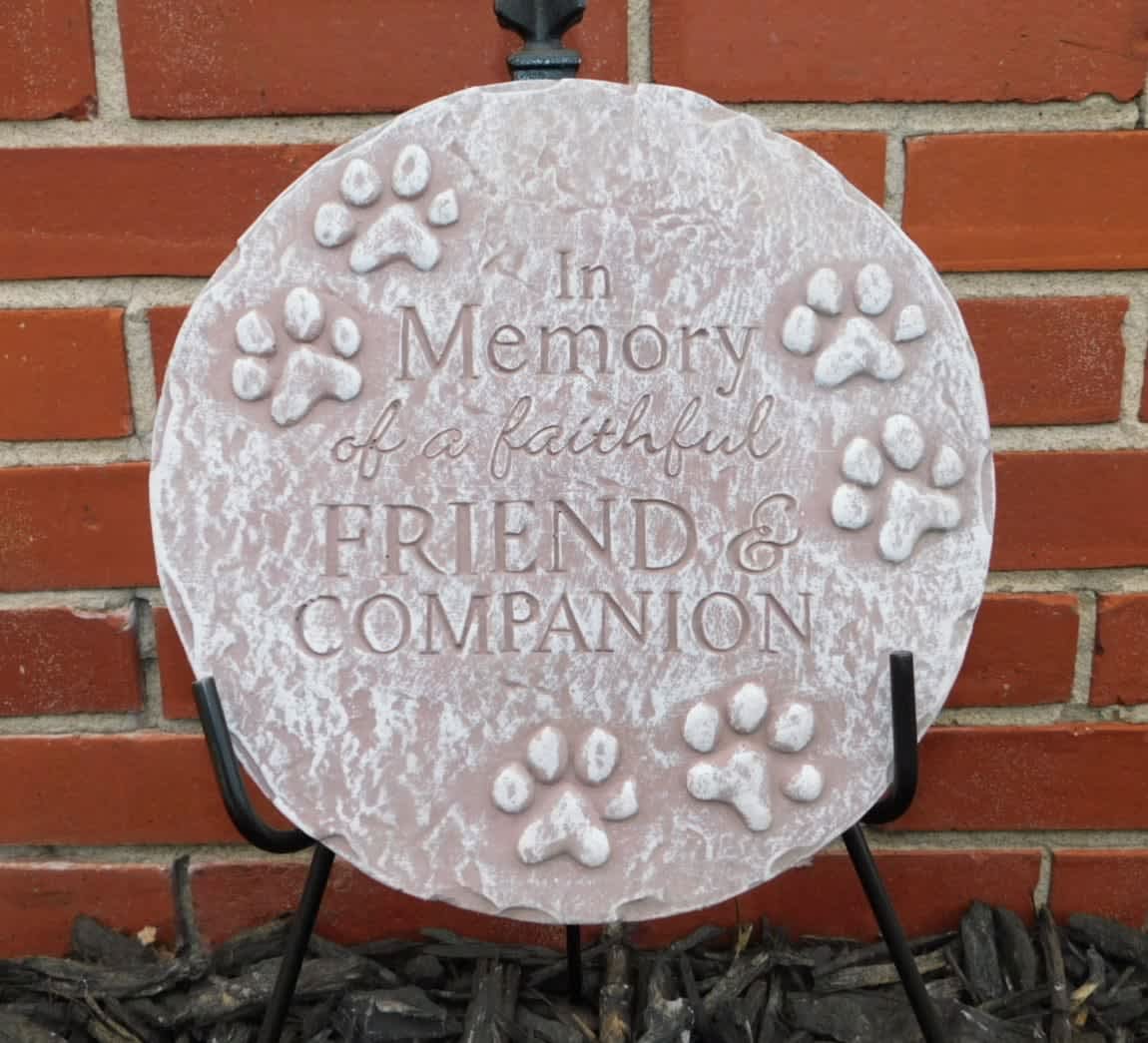 Round memorial plaque with paw prints and the words In Memory of a faithful Friend &amp; Companion