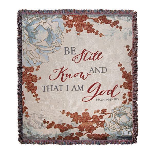 Fringed throw blanket with floral print and the words "Be Still and Know"