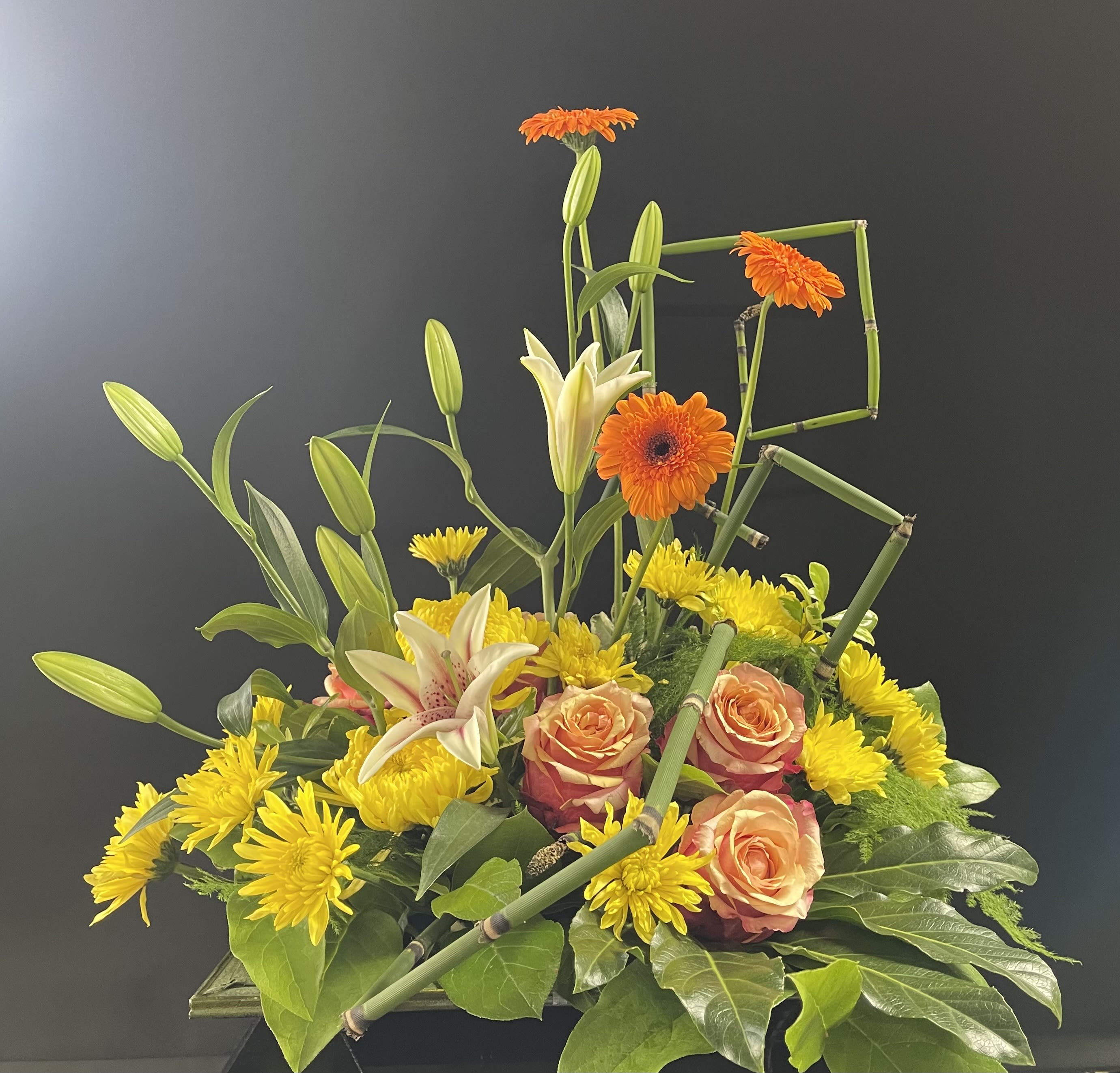 Mixed bouquet with orange gerberas, peach roses, yellow lilies, and chrysanthemums