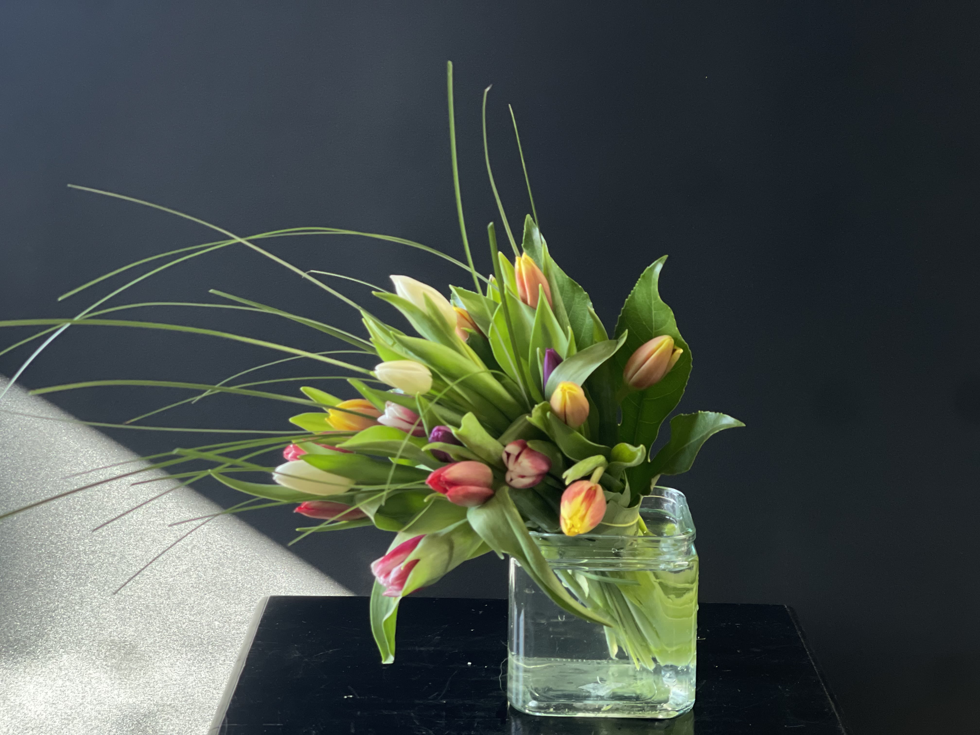 Bouquet of multicolored tulips in a clear glass vase