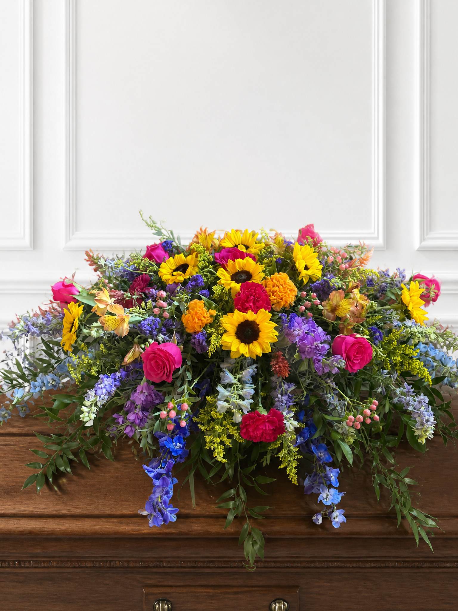 Colorful mixed flower arrangement on a wooden casket