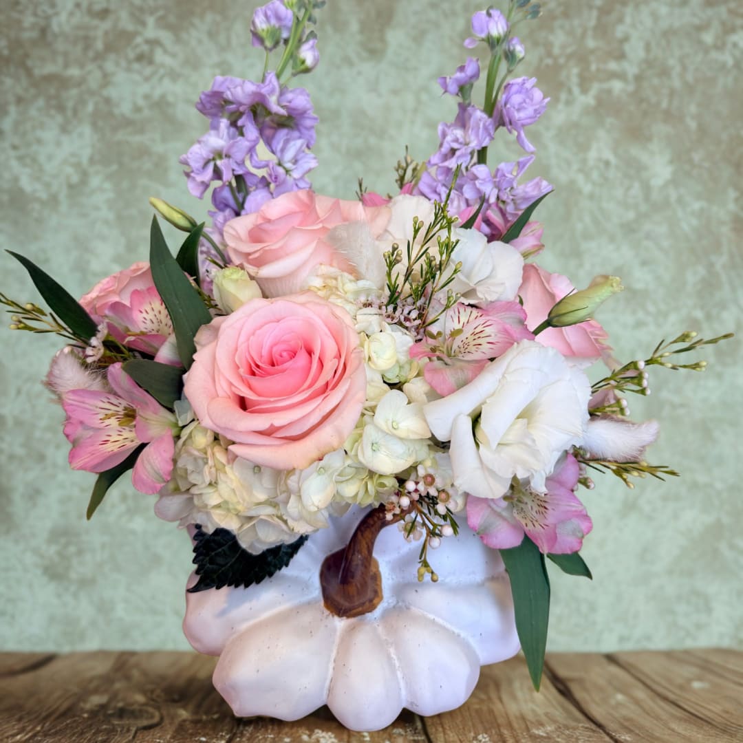 Pink and white floral arrangement in a white pumpkin vase