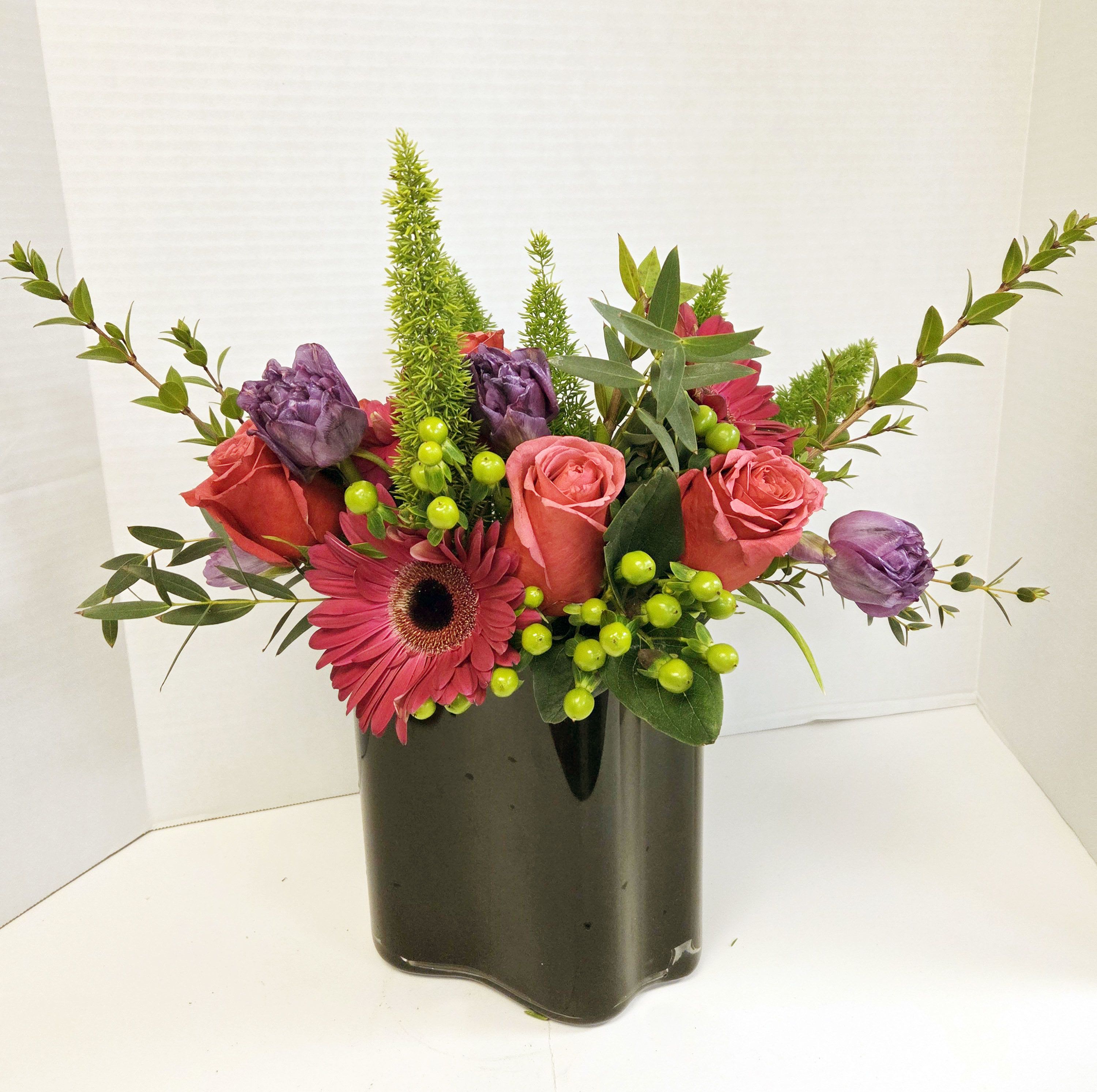 Pink and purple flower arrangement in a dark vase
