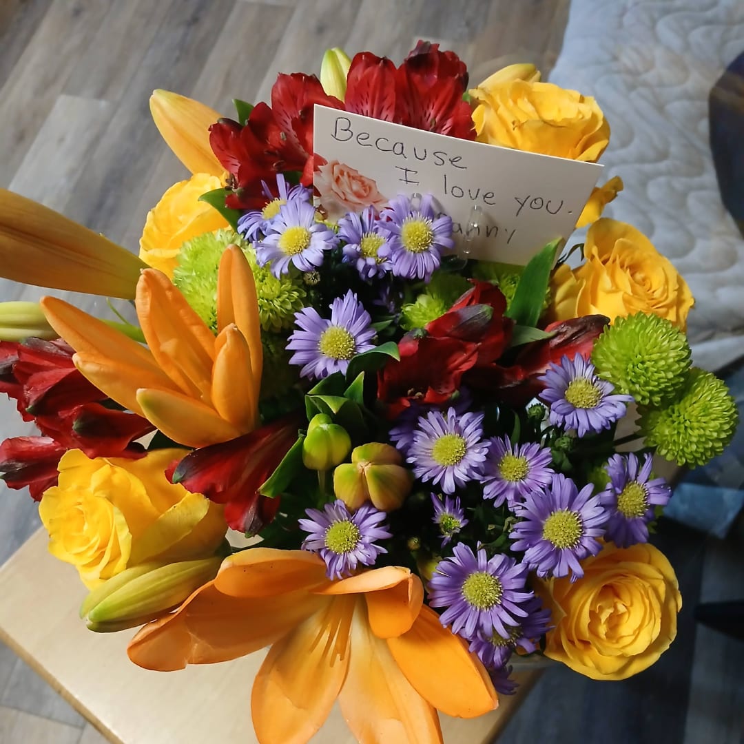 Colorful bouquet with yellow roses, orange lilies, and purple daisies