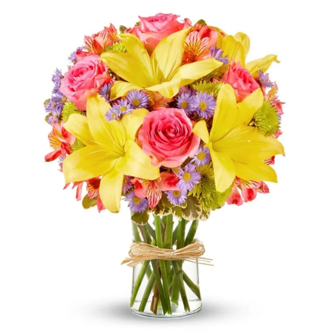 Bouquet of pink roses, yellow lilies, and purple daisies in a glass vase