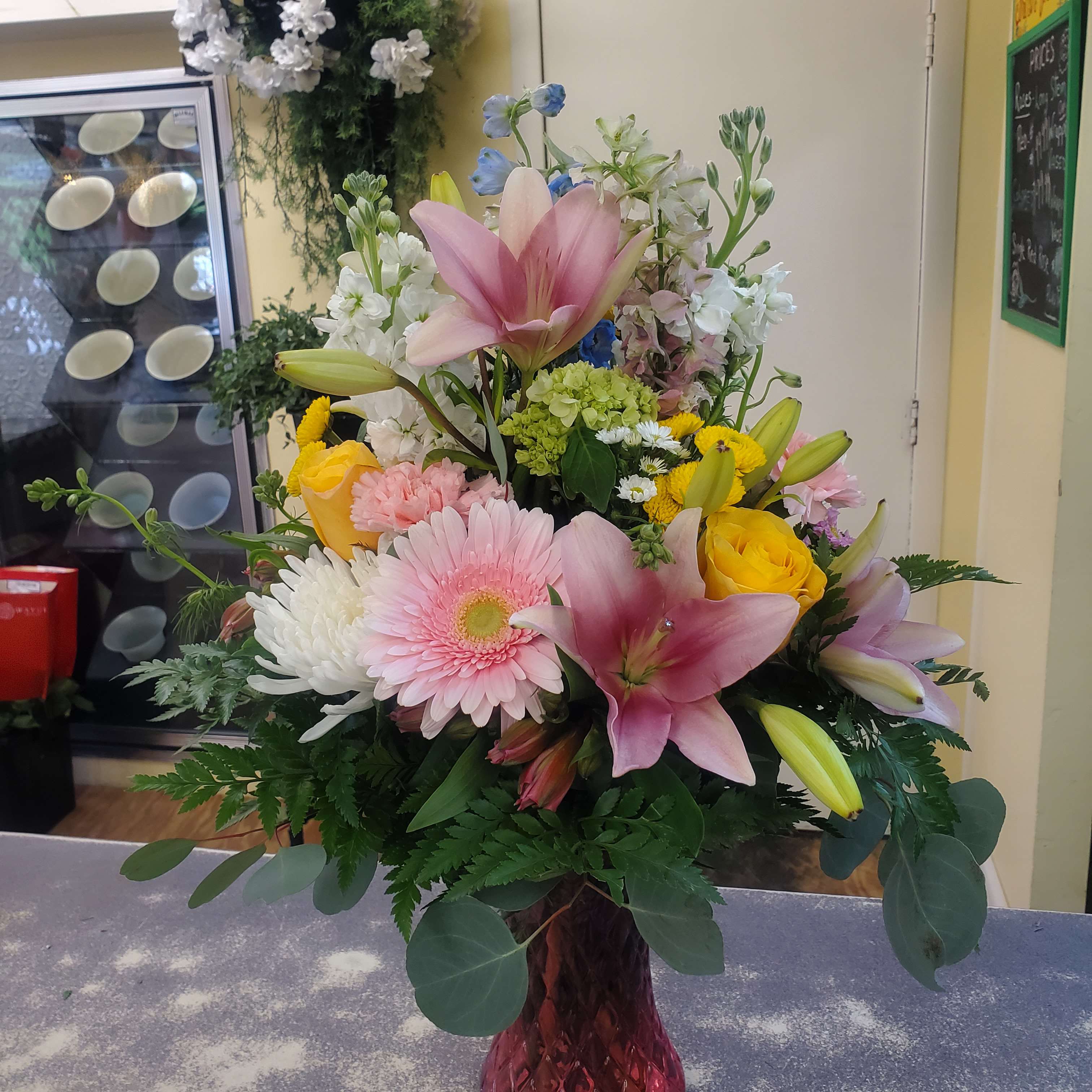 Mixed bouquet with pink lilies, roses, gerbera daisies, and white blooms in a vase