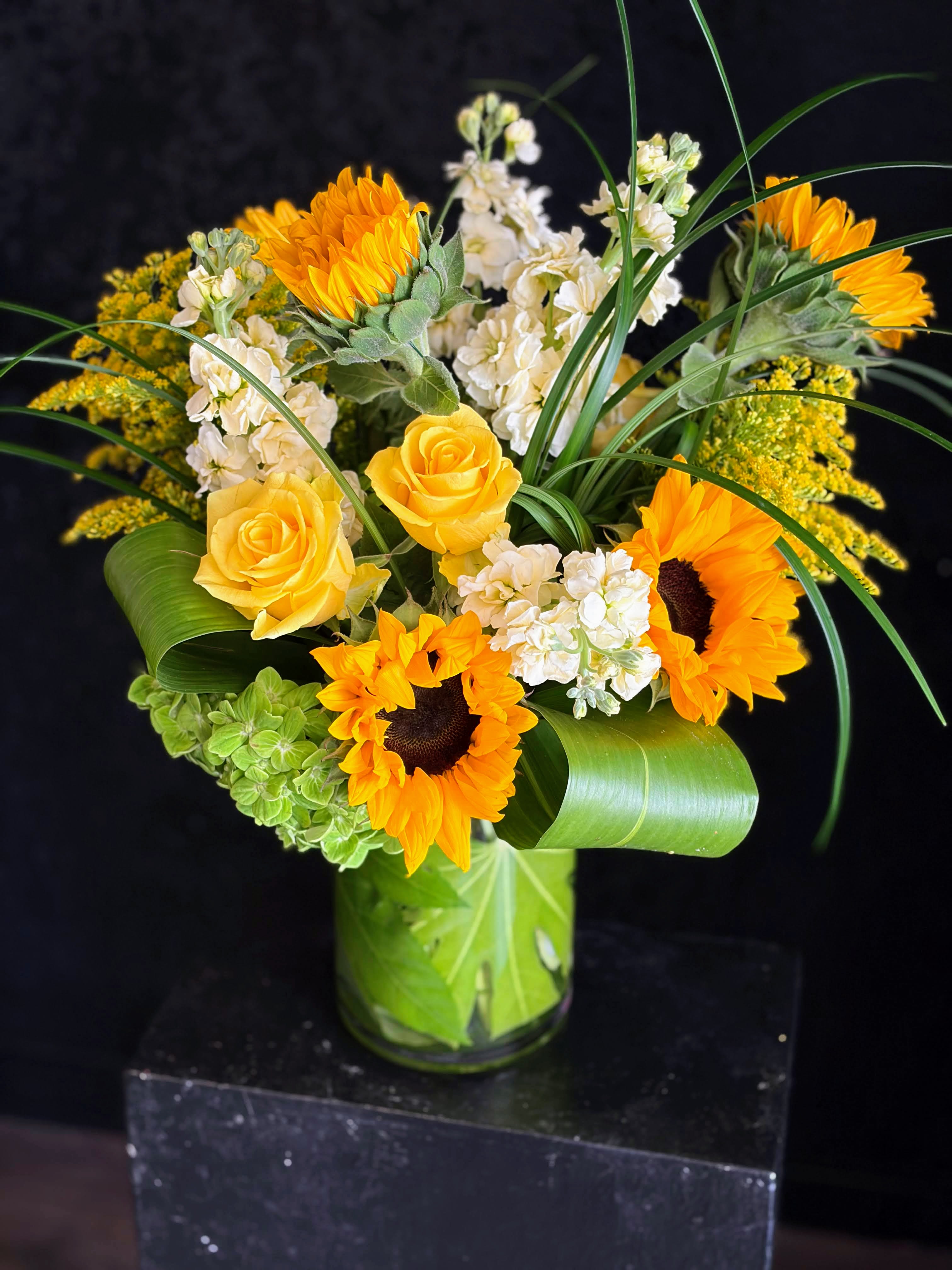 Sunny Side of Life - Sun-soaked and cheerful, this more traditional-style arrangement will brighten the home or office. Designed in a cylinder approximately 5x8".