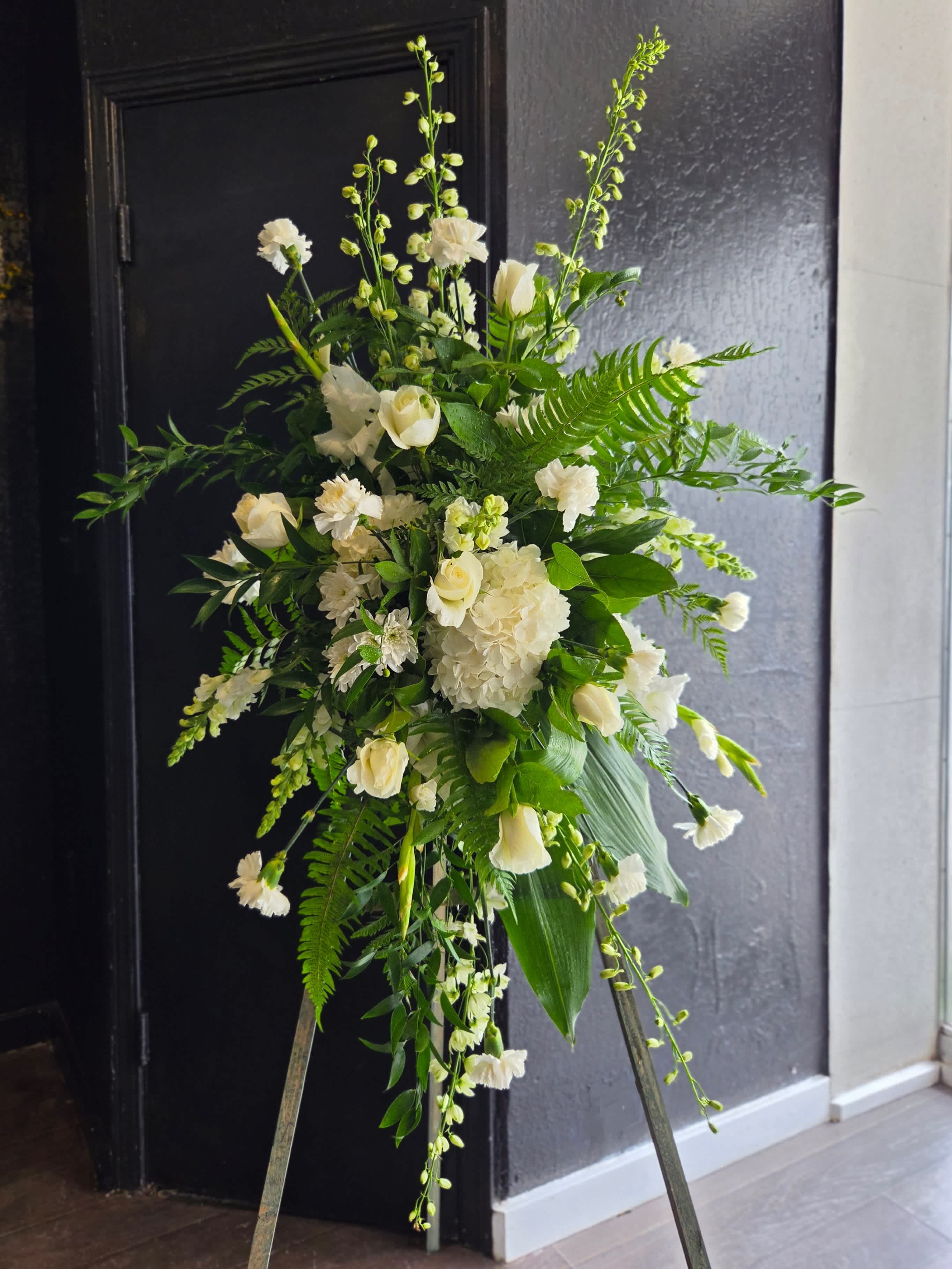 Tall white floral standing arrangement with mixed greenery