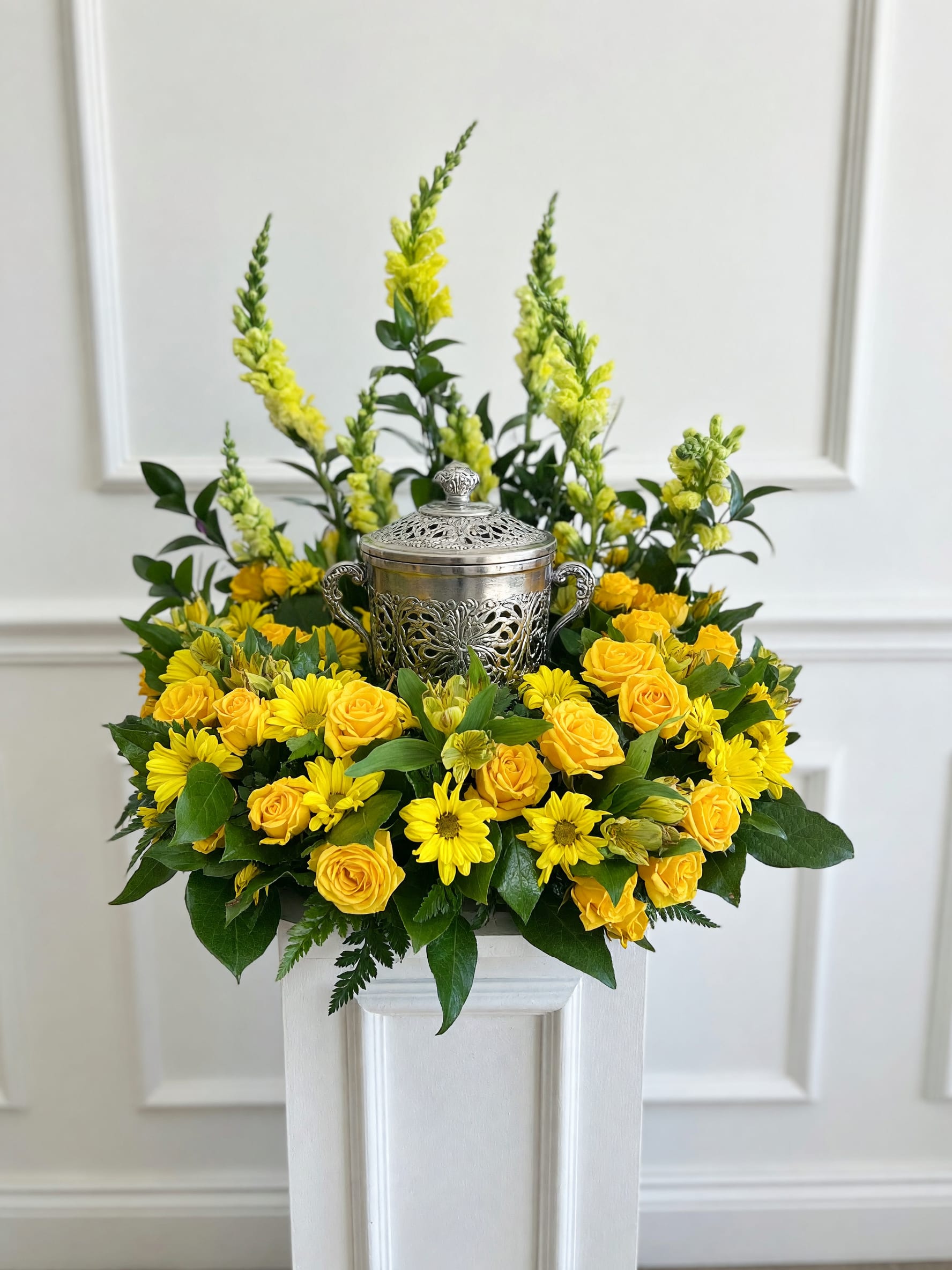 Eternal Light - Honor a loved one's memory with Eternal Light, an elegant cremation urn floral arrangement handcrafted with premium yellow roses, vibrant yellow daisy chrysanthemums, graceful snapdragons, alstroemeria, and fresh seasonal greenery. Designed to surround a keepsake urn with beauty and dignity, this heartfelt tribute brings comfort and peace to family and friends. Perfect for funeral services, memorial ceremonies, celebration of life gatherings, and lasting remembrances, Eternal Light is a timeless expression of love, honor, and cherished memories.