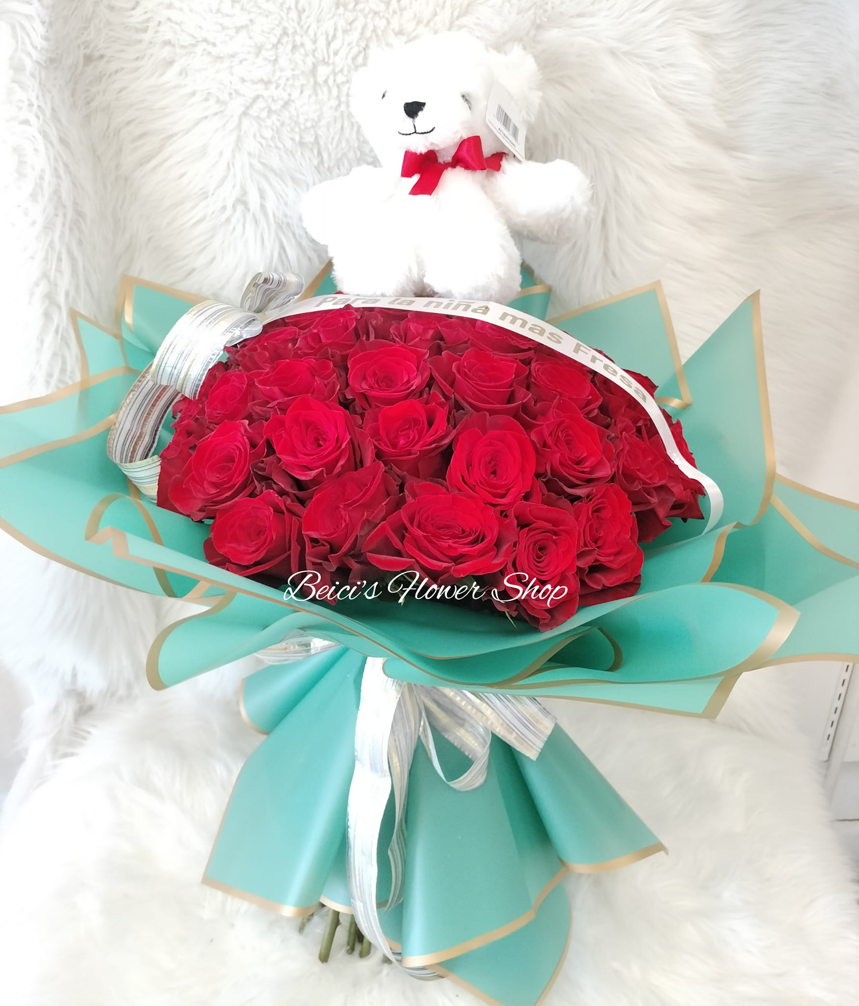 Red rose bouquet with a white teddy bear on top