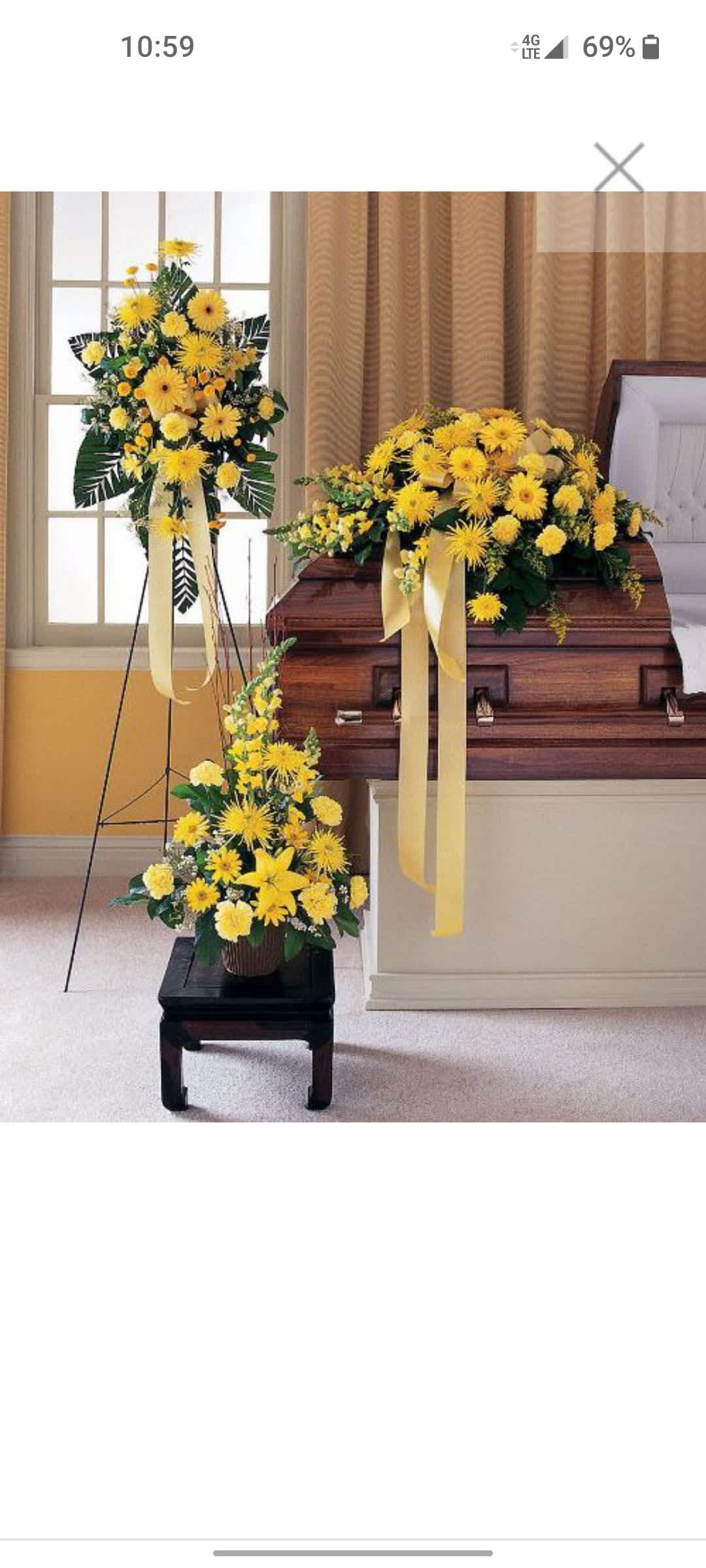Yellow floral funeral casket spray with matching standing and floor arrangements
