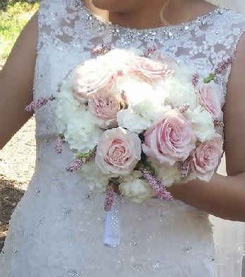 Bride holding a bouquet of pale pink roses and white flowers