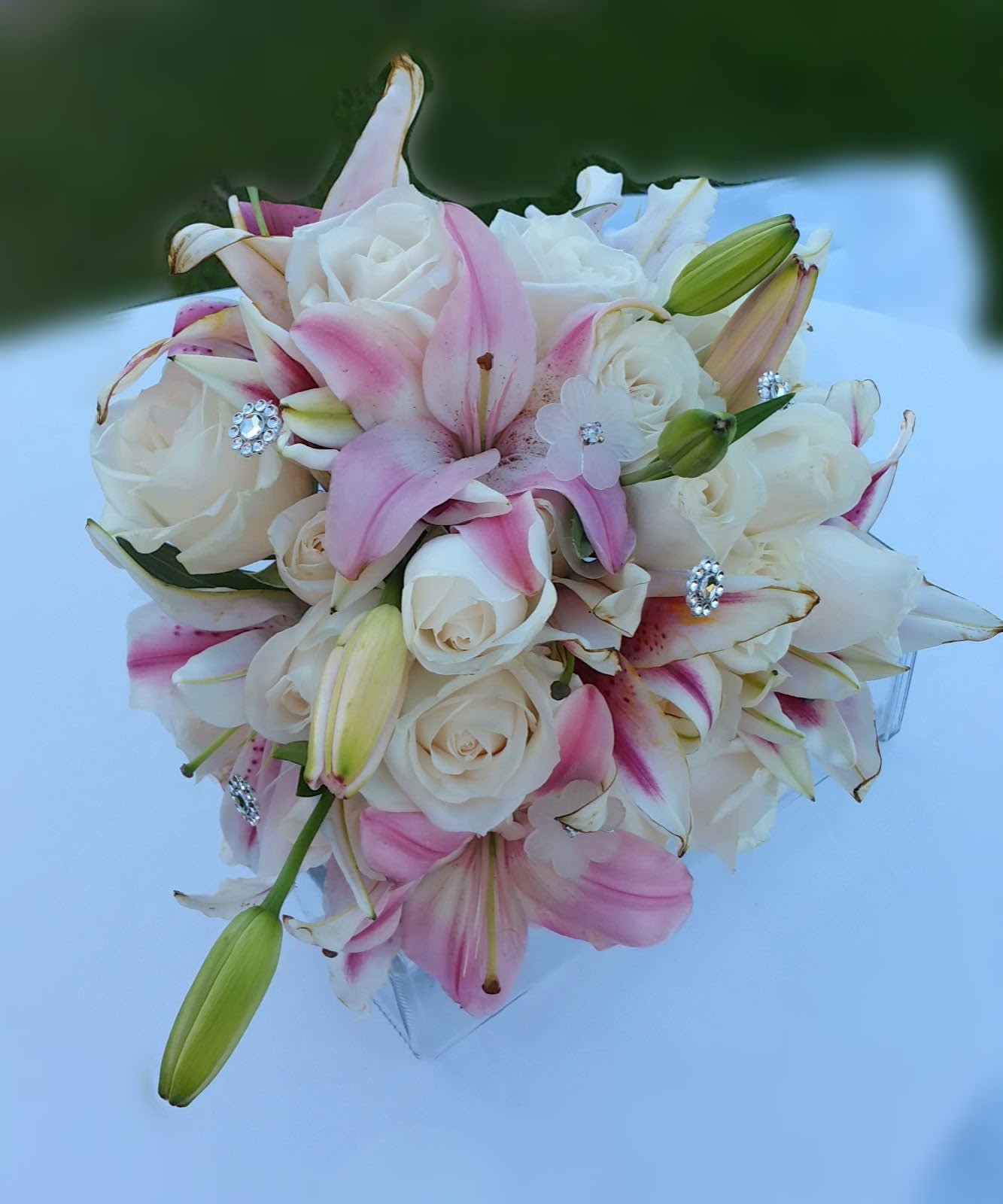Bouquet of white roses and pink lilies with jeweled accents