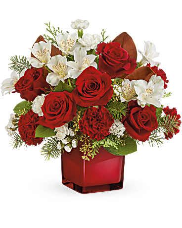 Red roses and white flowers arranged in a red glass vase