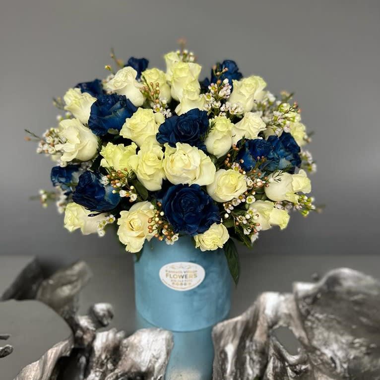 Blue and white rose bouquet in a light blue vase