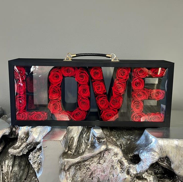 Black box display spelling LOVE filled with red roses