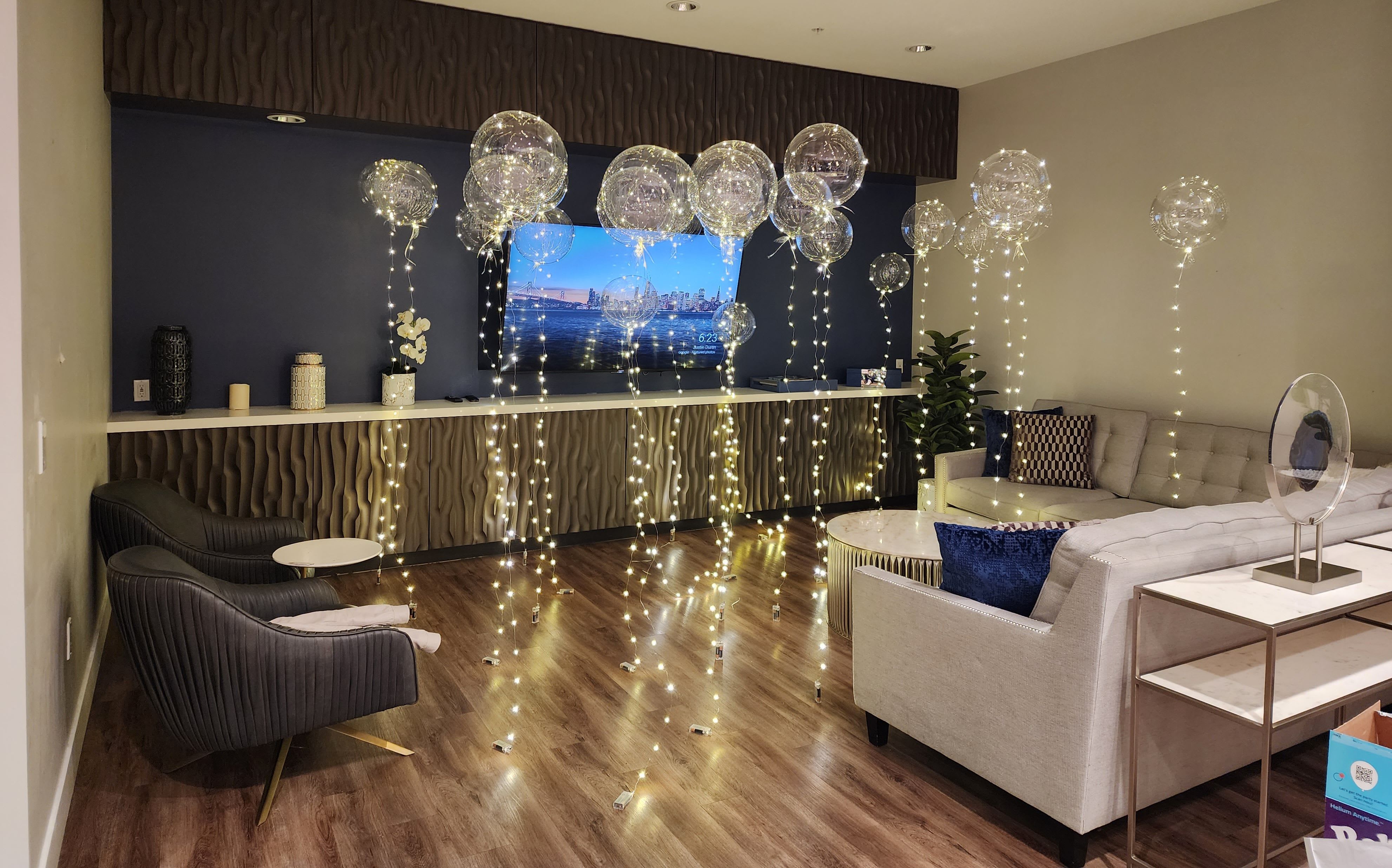 Living room decorated with clear balloons and string lights